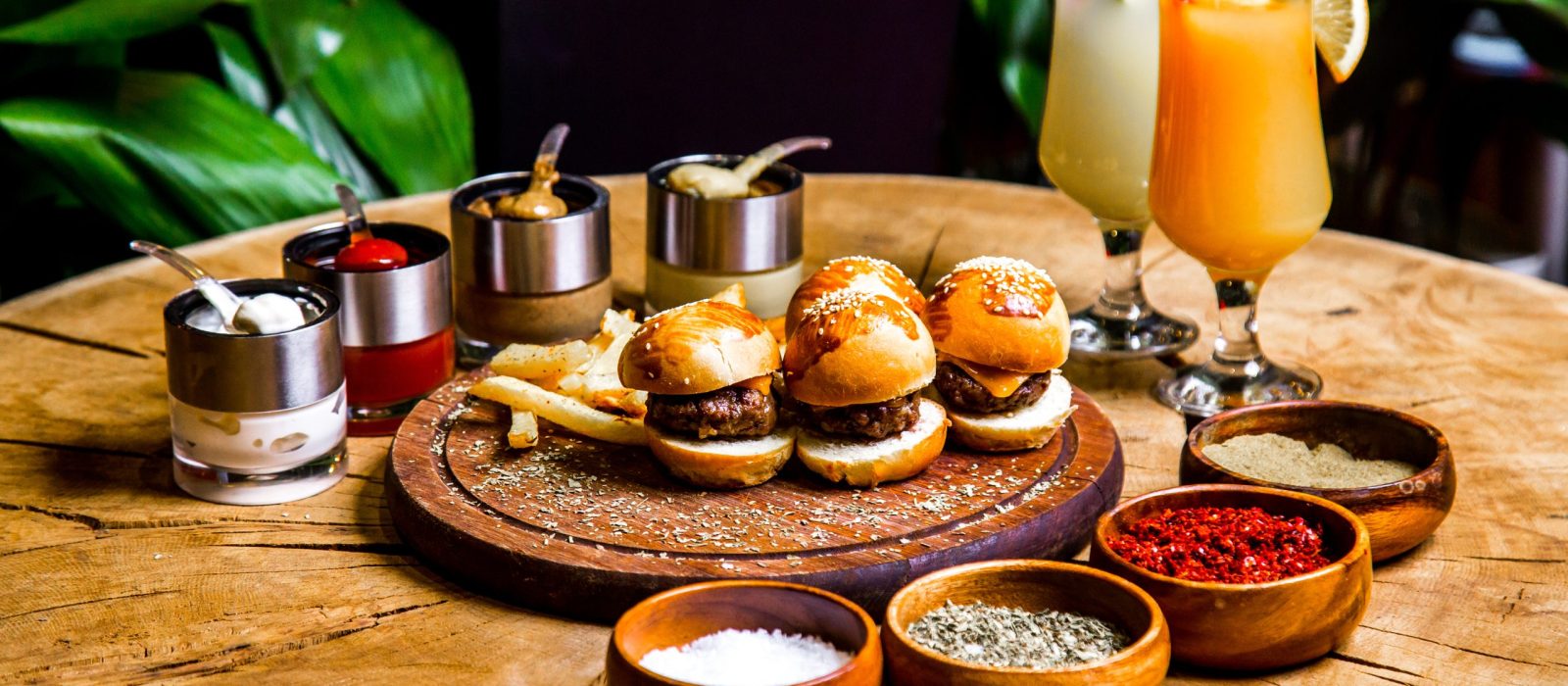 mini-burgers-french-fries-spices-sauces-cocktails-side-view